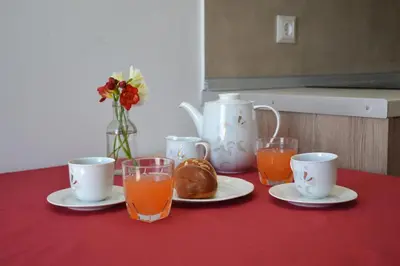 a table with cups and plates of food and orange juice at Depie Luxury Apartment in Pastida Rhodes in Pastida