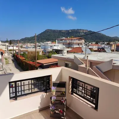 a house with two windows and a view of a city at Depie Luxury Apartment in Pastida Rhodes in Pastida