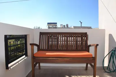 a bench sitting on a balcony with a window at Depie Luxury Apartment in Pastida Rhodes in Pastida