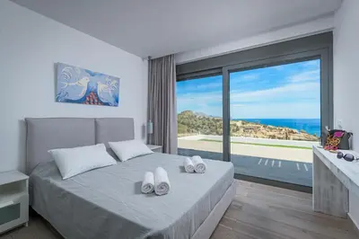 a bedroom with a bed with a view of the ocean at Villa Kastro in vlicha
