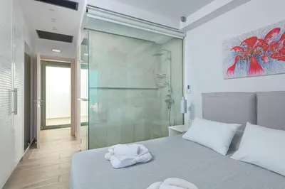 a bedroom with a shower and a bed with towels on it at Villa Kastro in vlicha