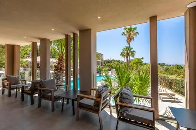 a dining room with a view of the ocean and palm trees at White Olive Premium Lindos in Pefki Rhodes