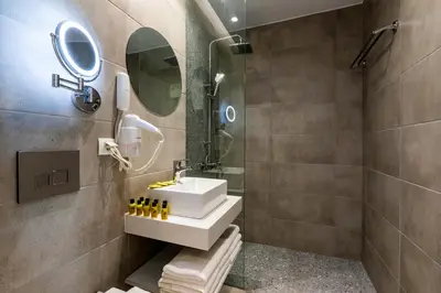 a bathroom with a sink and a shower at White Olive Premium Lindos in Pefki Rhodes