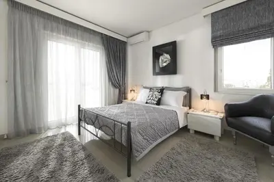 a bedroom with a bed and a chair and a window at City Mansion Rhodes in Rhodes Town