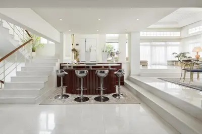 a living room with a staircase and a kitchen with stools at City Mansion Rhodes in Rhodes Town