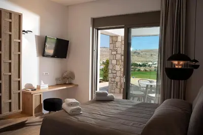 a bedroom with a bed and a view of a patio at Villa Alkyoni Lindos in Líndos