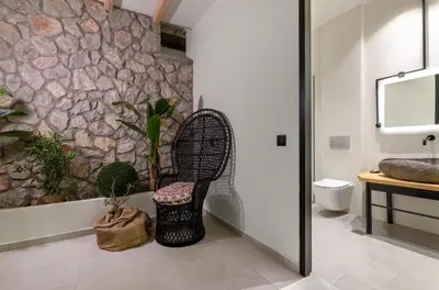 a bathroom with a chair and a stone wall at Lido Blue Villa in Pefki Rhodes
