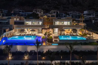 a villa with two swimming pools at night at Lido Blue Villa in Pefki Rhodes