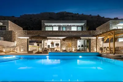 a large blue swimming pool in front of a house at Lido White Villa in Pefki Rhodes