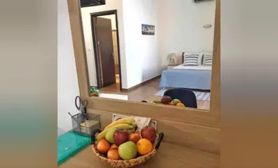 a bowl of fruit on a table in front of a mirror at Grande Blue Suites with private bay in Archangelos