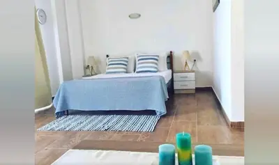 a bedroom with a bed with blue and white pillows at Grande Blue Suites with private bay in Archangelos