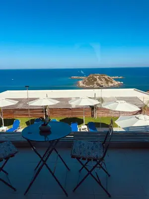 a patio with a table and chairs and the ocean at Grande Blue Suites with private bay in Archangelos