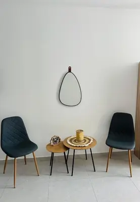 two chairs and a coffee table in a room at Grande Blue Suites with private bay in Archangelos