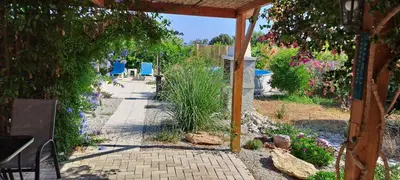 a garden with a stone walkway with chairs and flowers at Villa Soroni in Soroni