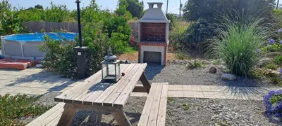 a wooden bench and a bird house in a garden at Villa Soroni in Soroni