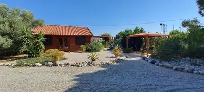 a house with a gravel driveway next to a building at Villa Soroni in Soroni