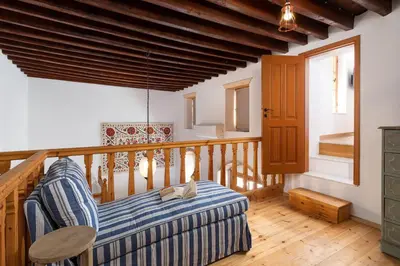 a room with a balcony with a couch and a table at Villa Lindia in Líndos