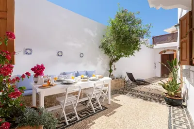 a white table and chairs in a courtyard with a tree at Villa Lindia in Líndos