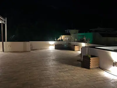 a patio at night with lights on a fence at Reginas Apartments in Ixia