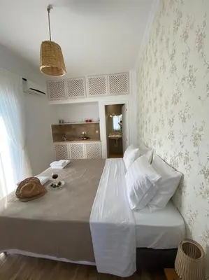 a bedroom with a large bed with a hat on it at Reginas Apartments in Ixia
