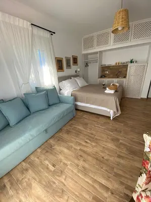 a living room with a couch and a bed at Reginas Apartments in Ixia