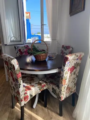 a table and two chairs with a table and a window at Reginas Apartments in Ixia