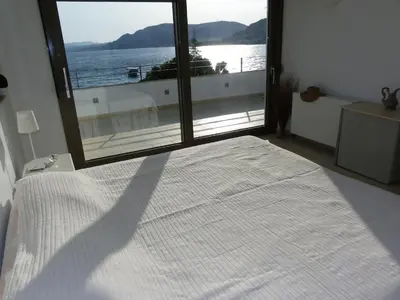 a bedroom with a bed with a view of the ocean at Pefkos Beachfront Villa in Pefki Rhodes