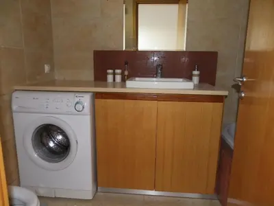 a bathroom with a sink and a washing machine at Pefkos Beachfront Villa in Pefki Rhodes