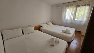 two beds in a small room with a window at Pefkos Beachfront Villa in Pefki Rhodes