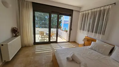a bedroom with a bed and a view of the ocean at Pefkos Beachfront Villa in Pefki Rhodes