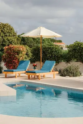 two chairs and an umbrella next to a swimming pool at Gennadi Dreams Holiday Villa in Gennadi