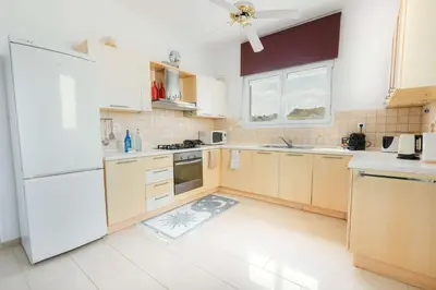 a kitchen with wooden cabinets and a white refrigerator at Gennadi Dreams Holiday Villa in Gennadi