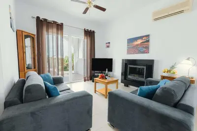 a living room with two blue couches and a fireplace at Gennadi Dreams Holiday Villa in Gennadi