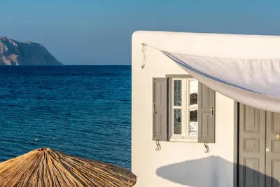 a building with a window next to the water at On The Rocks in Symi