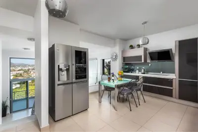 a kitchen with a table with chairs and a refrigerator at Articiano Villa in Faliraki