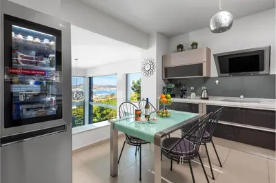a kitchen with a table and chairs in a kitchen at Articiano Villa in Faliraki