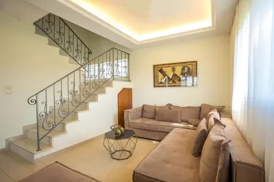 a living room with a couch and stairs at Muses villa in Pastida