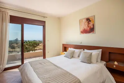 a bedroom with a large bed and a large window at Muses villa in Pastida
