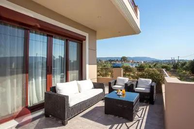a patio with wicker chairs and a table on a balcony at Muses villa in Pastida