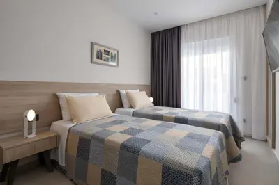 a hotel room with two beds and a window at Kallia Sea Breeze - 3 Bedroom Apartment in Rhodes Town