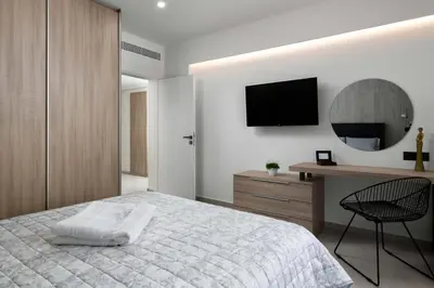 a bedroom with a bed and a desk and a television at Kallia Sea Breeze - 3 Bedroom Apartment in Rhodes Town