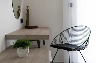 a chair sitting next to a table with a plant at Kallia Sea Breeze - 3 Bedroom Apartment in Rhodes Town