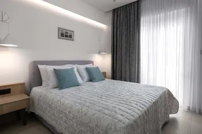 a bedroom with a large bed with blue pillows at Kallia Sea Breeze - 3 Bedroom Apartment in Rhodes Town