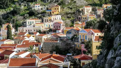 a village on a hill with colorful houses at Casa Di Rosse in Symi