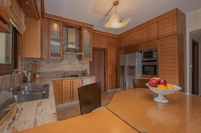 a kitchen with a bowl of fruit on a wooden table at Emma's Luxury Villa in Pastida