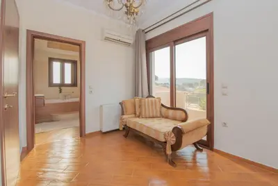 a living room with a couch and a large window at Emma's Luxury Villa in Pastida