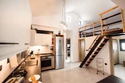 a kitchen with a staircase leading up to a loft at El Sueno Villa in Gennadi