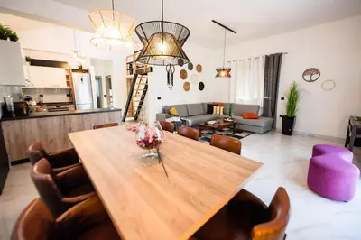 a dining room and living room with a wooden table at El Sueno Villa in Gennadi