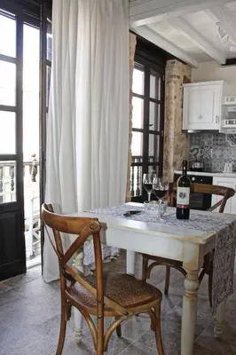 a kitchen with a table with two glasses of wine at Muse Neate in Halki