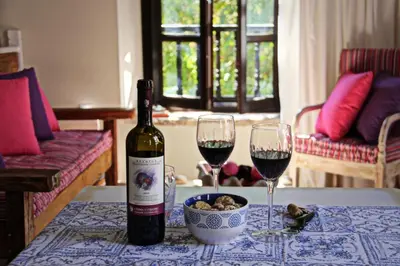 a bottle of wine and two glasses on a table at Muse Neate in Halki